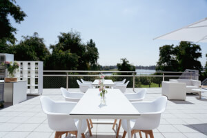 Sonnenterrasse der Veranstaltungsebene mit langer eingedeckter Tischtafel.